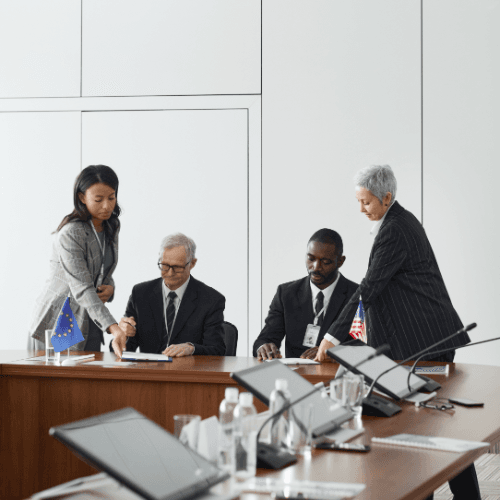 A group of people signing documents at a conference table